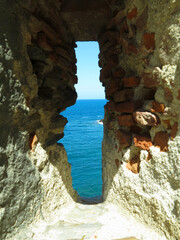 A view of the sea through the loophole of a medieval fort in the southern part of Colliure, France