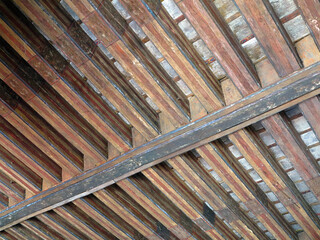 Aged beams in an old barn. Old roof achitecture detail.