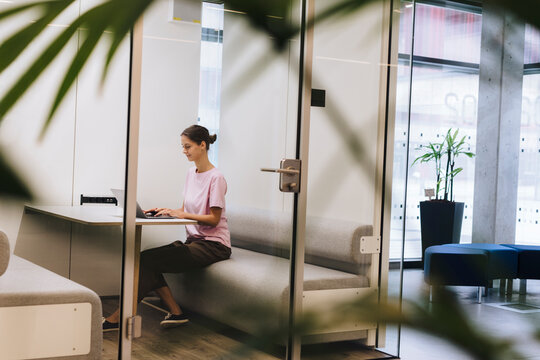 Young businesswoman working on laptop in office cubical