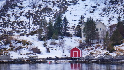Red house nearby the lake during winter season. 