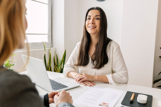 Smiling HR manager discussing with candidate in office