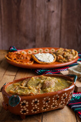 Chicharrones in green sauce, typical mexican food. Mexican food in clay pot.
