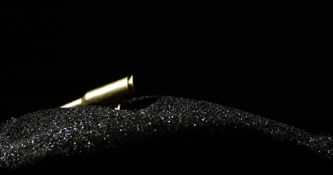 6mm Advanced Rifle Cartridge Falling Into The Black Powder. - closeup, slow motion shot
