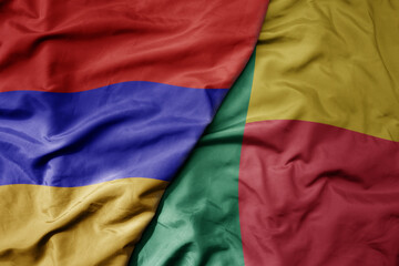 big waving national colorful flag of benin and national flag of armenia .