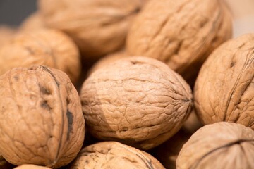 Nature's Bounty: A Close-Up of Fresh, Organic Walnuts, This image features a close-up view of a group of fresh, organic walnuts. The intricate textures and rich, earthy tones of the walnuts