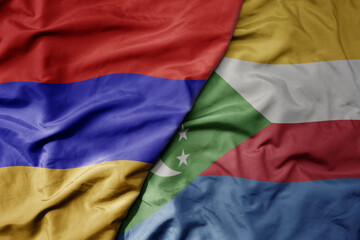 big waving national colorful flag of comoros and national flag of armenia .