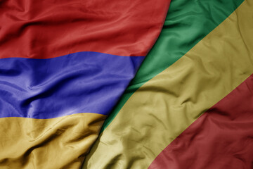 big waving national colorful flag of republic of the congo and national flag of armenia .