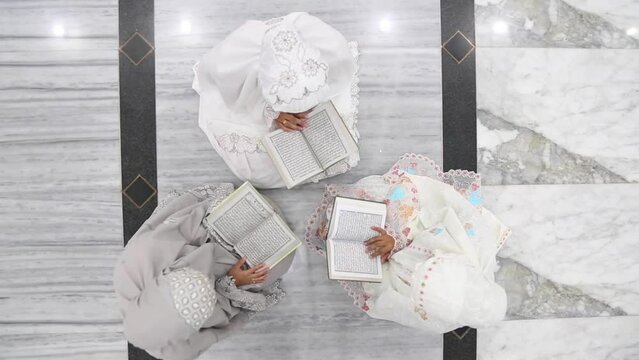 Three moslem women reading the Koran