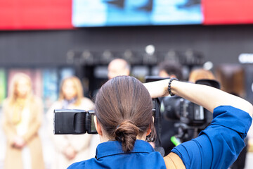 Female photographer photographing press conference, media or news event