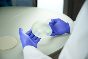 Close-up of female plastic surgeon demonstrates breast implants to a patient for her new breast....