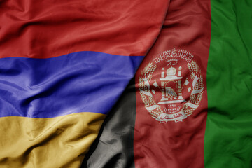 big waving national colorful flag of afghanistan and national flag of armenia .