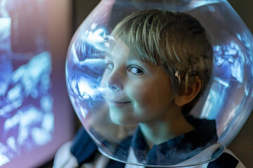 Cute child, boy, dreaming of becoming astronaut and flying into space. reflection of moon in his...
