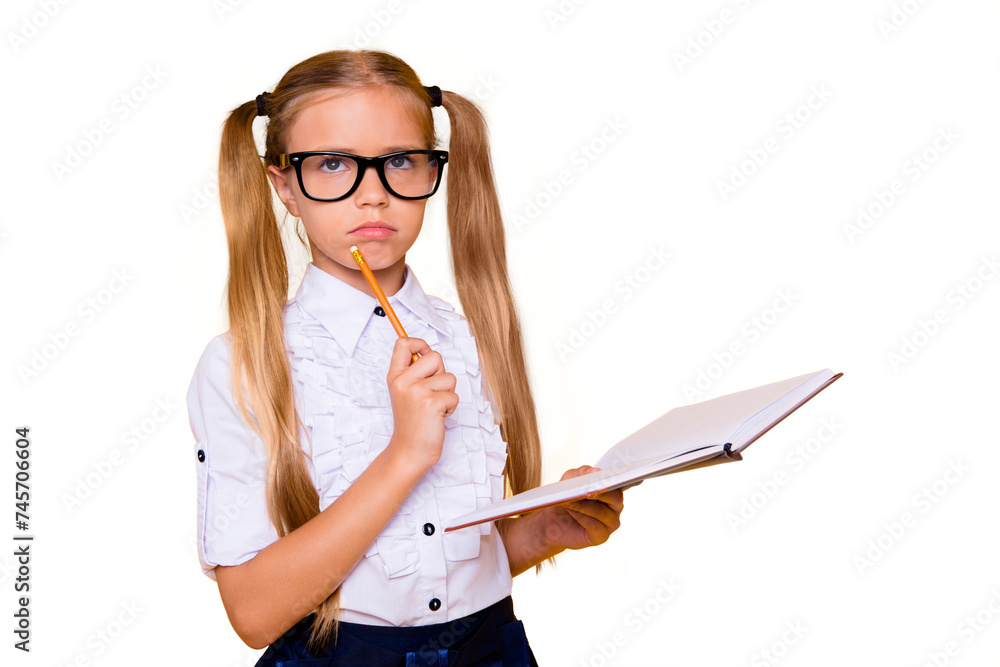 Wall mural Close up studio photo portrait of little cute contemplating sweet with two ponytails long hairdo schoolchild looking up holding notebook in hand solving hard test isolated bright background