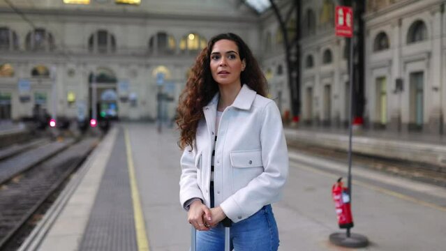 Young beautiful woman standing at platform station waiting the train. Travel concept. 