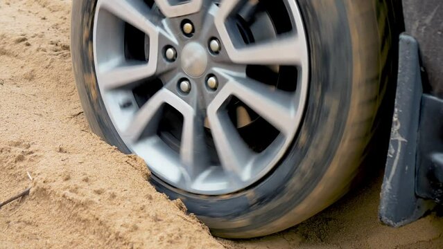Tires skids on sandy road close up. Car in sand . SUV vehicle was stuck on dirty off road. SUV vehicle struggling to gain traction in sand, off road in desert