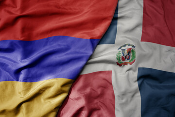 big waving national colorful flag of dominican republic and national flag of armenia .