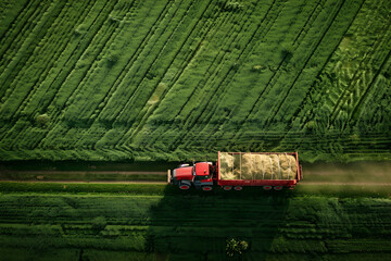 Traktor mit Anhänger, gefüllt mit Gras auf auf Wiese, Luftbild, Vogelperspektive, Landwirtschaft, erstellt mit generativer KI - obrazy, fototapety, plakaty