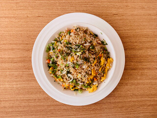 Egg fried rice in a bowl on a brown wooden table