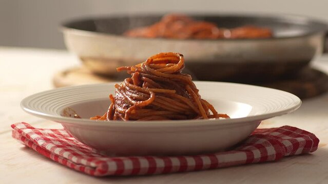 Steaming Pasta with Tomato Sauce. Step of Recipe Fried Assassin's Spaghetti Cooking. Close-up, shallow dof.