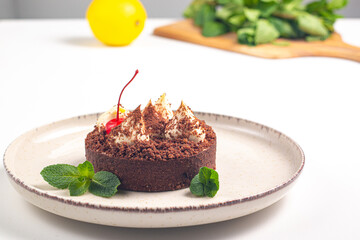 Delicious chocolate tart garnish with cherry and mint. Classic dessert. - 745728497