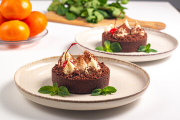 Delicious chocolate tart garnish with cherry and mint. Classic dessert. - 745728609