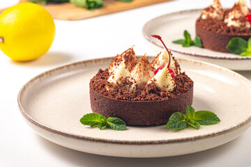 Delicious chocolate tart garnish with cherry and mint. Classic dessert. - 745728622