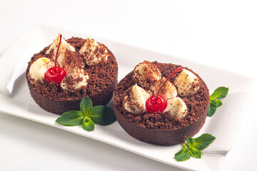 Delicious chocolate tart garnish with cherry and mint. Classic dessert. - 745728654
