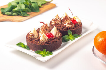 Delicious chocolate tart garnish with cherry and mint. Classic dessert. - 745728689