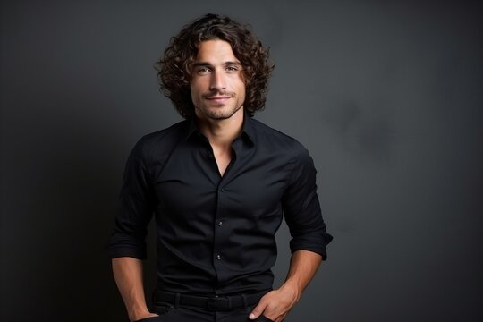 Portrait of a handsome young man with long curly hair, studio shot