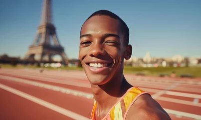Fotobehang Smiling black man male athlete on athletics track, Eiffel Tower like structure behind. Concept shot for 2024 Olympics in Paris, France, Europe. Isolated modern. Not an actual depiction of the event © Goodwave Studio