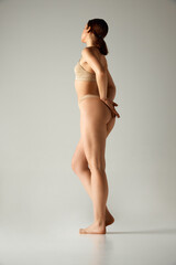 Side view full-length image of young girl with with, smooth, slim body, buttocks. Model posing in...