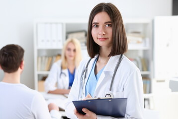 Beautiful smiling female doctor stand in office