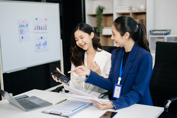 Businesswomen work and discuss their business plans. A Human employee explains and shows her colleague the results paper