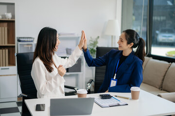 Obraz premium Female discussing new project with Female colleague. Young women talking with young Asian man in office.