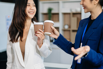 Two business worker standing and holding a coffee cup in modern office, successful, celebration, new project, team office concept