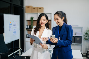 Businesswoman leading team meeting and using tablet and laptop computer with financial in co working