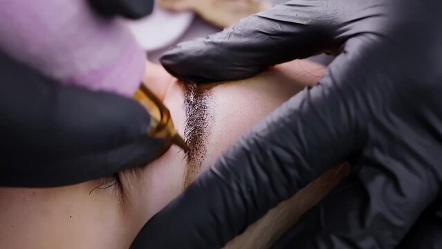 Shooting a macro video of pigment application to the eyebrow skin at a permanent eyebrow makeup procedure. Permanent makeup procedure, performing PMU of eyebrows