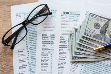 Form 1040 with pen and glasses, tax payment