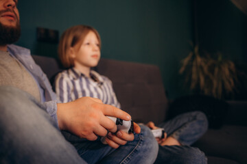 Excited by videogame victory little kid girl and her father raised hands scream with joy sit on...