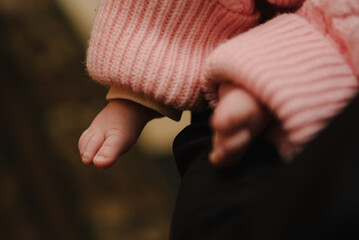 Small bare feet of a girl. Barefoot. A mother holds a baby in her arms. Tiny, feet of newborn...