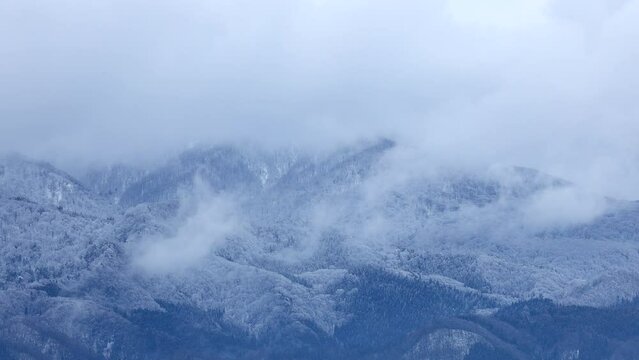 山の頂上に降った雪　雲の動き　冬　イメージ