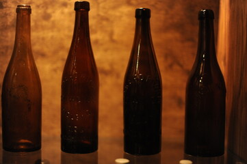 Empty antique brown beer bottles standing in a row on a shelf in a cellar