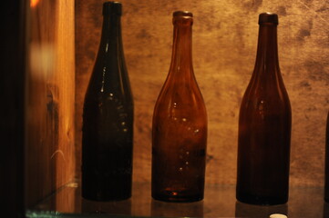 Empty antique brown beer bottles standing in a row on a shelf in a cellar