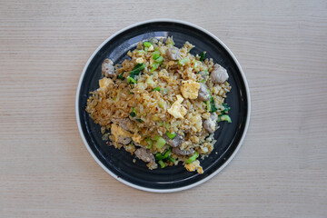 A plate of pork and egg fried rice.