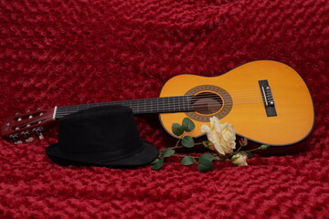 guitarra sombrero negro rosa amarilla sobre fondo rojo 