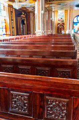 Empty wooden church benches of a Christian church. Blurry alter in the background. Selective focus....