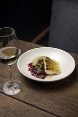 Baked fish with zucchini and dill on a white plate