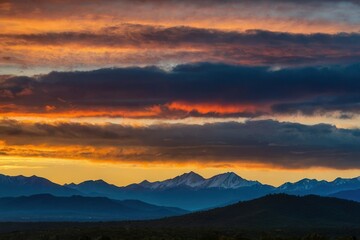 a panoramic shot of a vibrant sunrise over a tranquil mountain range