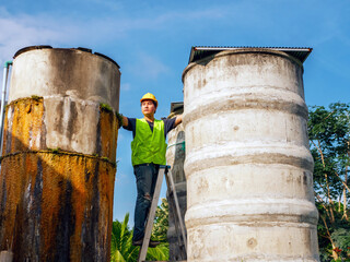 engineer controlling the quality of water Stand on the risky stairs at high places operating...