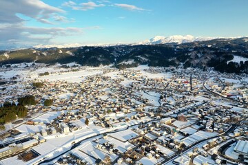 ドローン撮影：真っ白な雪に覆われた田舎町の住宅街